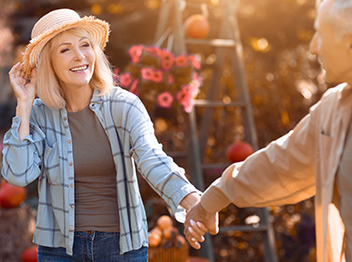 Older couple holding hands outdoors, representing lasting oral health and quality dental care for seniors