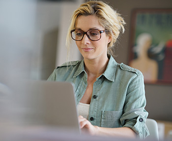 Woman using laptop to schedule dental appointment online, representing convenient patient booking and virtual consultations