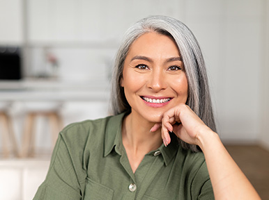 Older woman smiling confidently, representing healthy smile results from restorative or cosmetic dentistry